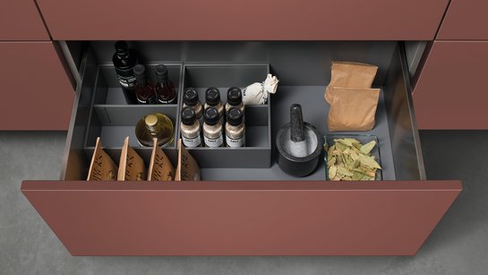 Offene Schublade in einer Küche mit Inneneinteilung für Vorräte