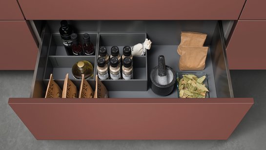 Offene Schublade in einer Küche mit Inneneinteilung für Vorräte