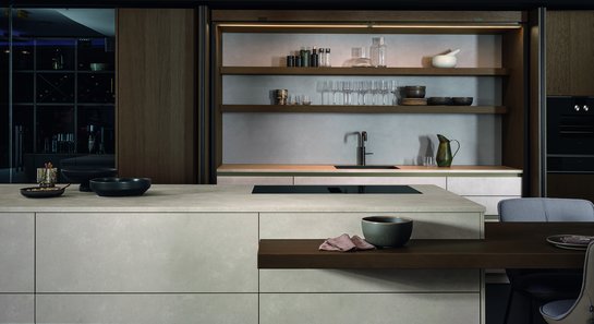 Kücheninsel mit Barplatte, dahinter ein offener Falttürschrank