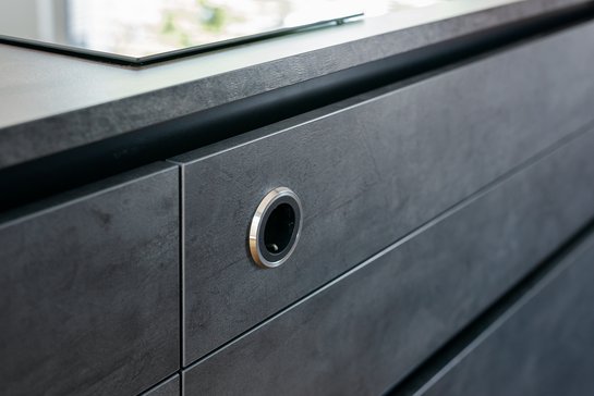 Detailansicht einer Küchenfront in Betonoptik mit Steckdose