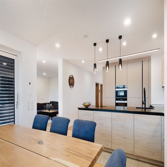 Bei dieser U-Küche wurde hoher Wert auf eine nahtlose Verbindung zwischen Koch- und Essbereich gelegt.