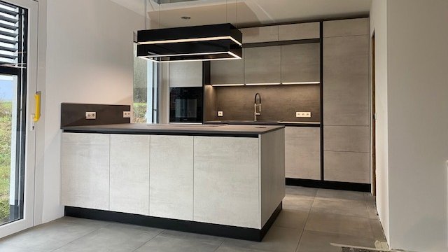 Kompakte kleine Inselküche in hellgrauer Betonoptik mit dunkler Arbeitsplatte