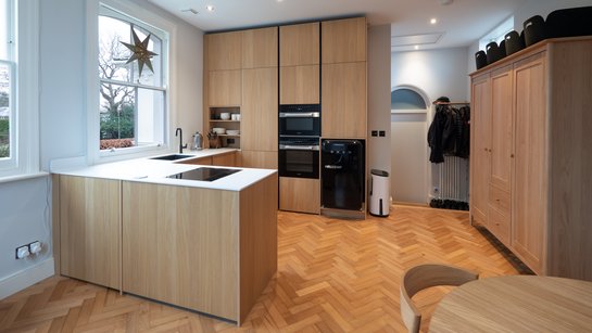 Kompakte U-förmige Küche in hellem Holzfurnier mit Insel und Hochschränken