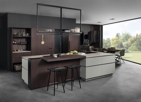 Inselküche in der gräulichen Farbe matcha latte mit dunklen Holzelementen und einer Bar