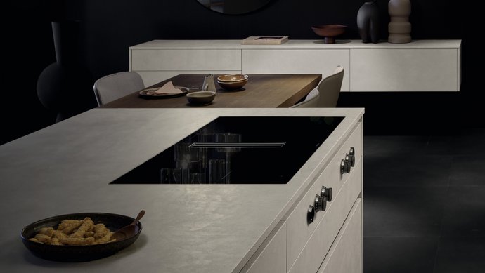 Ausschnitt einer Kücheninsel in Betonoptik mit eingebautem Kochfeld