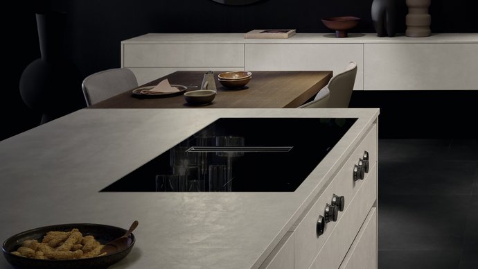 Ausschnitt einer Kücheninsel in Betonoptik mit eingebautem Kochfeld