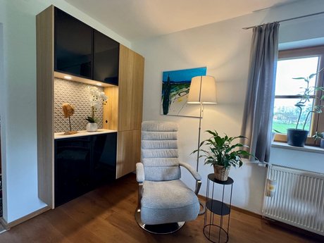 Hängender Stauraumschrank mit klarer Linienführung, dekoriert mit Pflanzen und Accessoires.