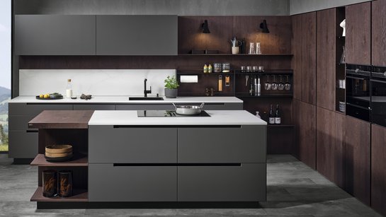 Inselküche mit grauen Fronten und Hochschrankgruppe in eiche dunkel