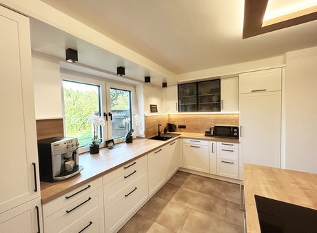 Weiße U-Küche im Landhausstil mit Rahmenfronten und Arbeitsplatte in Holzoptik