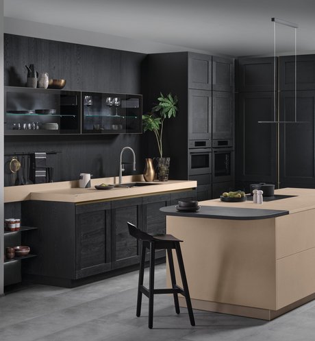 Moderne Kücheninsel in rötlicher Cemento-Optik mit schwarzen Holz-Hochschränken im Landhausstil
