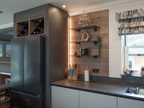 Moderne Küche mit integrierten Weinregalen über dem Kühlschrank.