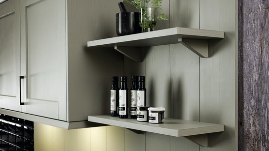 Konsolen-Wandborde, dahinter Oberschränke einer Landhausküche mit Rahmenfronten in salbei