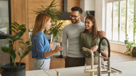 Küchenberatung durch den ewe Profi Eine Verkäuferin berät ein Paar zum Thema Küchenausstattung