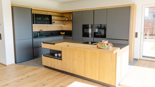 L-förmige Küche in grau mit Kücheninsel in wildeiche