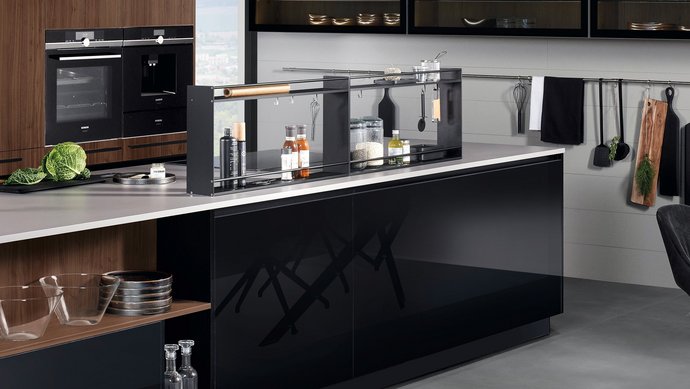 Kücheninsel in schwarz Hochglanz mit Hochschrankgruppe mit Fronten in ambernuss furniert