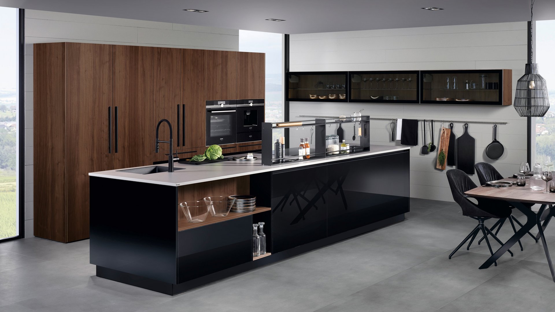 ewe Lucca . ewe Legno in schwarz . ambernuss, schräge Hauptansicht Kücheninsel in schwarz Hochglanz mit Hochschrankgruppe mit Fronten in ambernuss furniert