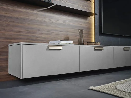 Sideboard in grauer Strukturoberfläche mit bronzefarbenen Griffprofilen