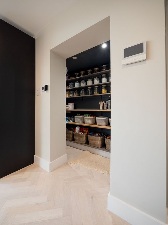Offener Durchgang zu einem Vorratsraum mit Regalen