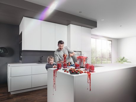 Vater und Sohn in weißer Küche beim Marmelade-Einkochen, alles tropft und spritzt