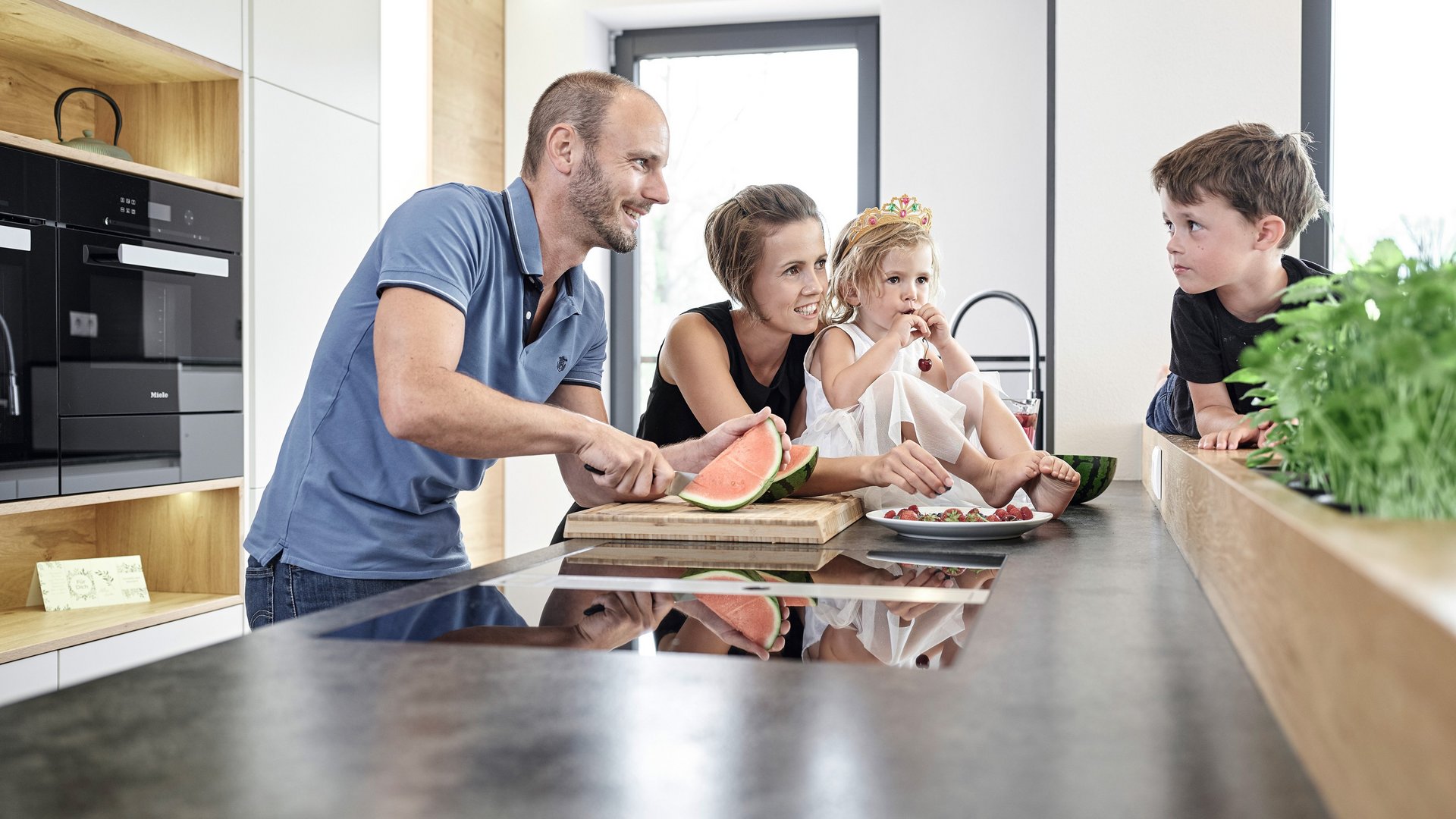 ewe ist Küchengenuss für Familien Eine Familie mit einem kleinen jungen und einem kleinen Mädchen kocht gemeinsam in der Küche