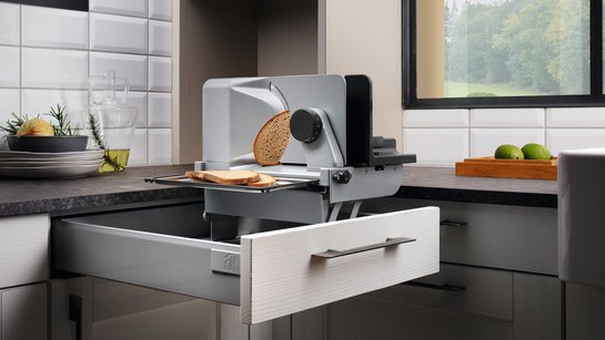 Offene Schublade in einer Küche mit einem eingebauten Allesschneider
