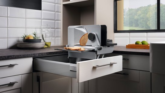 Offene Schublade in einer Küche mit einem eingebauten Allesschneider