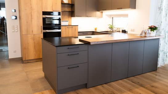 U-förmige Küche in grau supermatt in Kombination mit Schränken in Holz