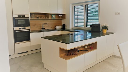 helle U-Küche mit weißen Fronten und Eichenelementen