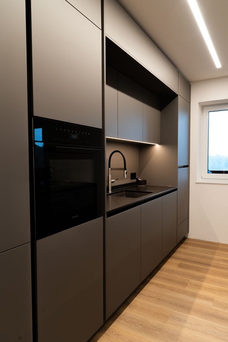 Detailansicht der Spülennische mit integrierter Beleuchtung und moderner Armatur.