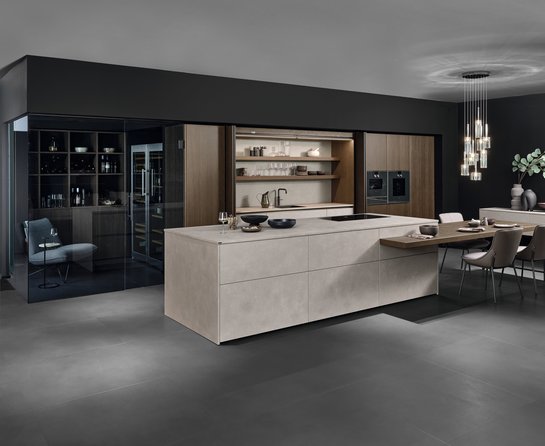 Graue Inselküche mit angesetzter Barplatte und Esstisch in dunklem Holz