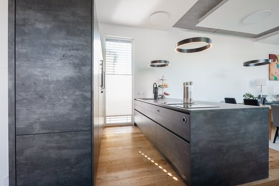 Seitliche Ansicht einer Inselküche im Industrial Style in der Farbe metall grau