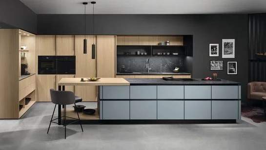 Graue Kücheninsel vor Hochschränken aus heller Eiche