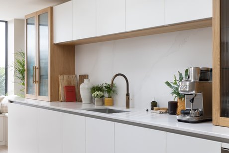 Weiße Küchenzeile mit weißen Oberschränken und einer Quooker®-Armatur