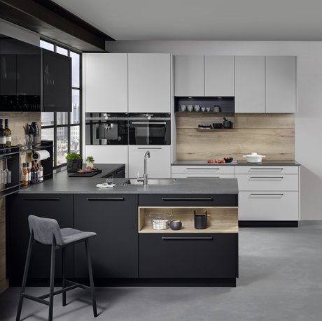 L-förmige Küche mit kieselgrauen Hoch- und Oberschränken und schwarzer Kücheninsel