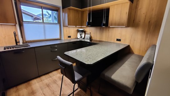 In diese moderne U-Küche wurde ein gemütlicher Sitzbereich integriert.