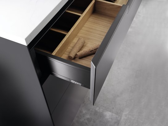 Geöffnete Schublade in Kücheninsel mit leerem Besteckeinsatz in eiche