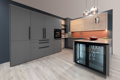 Die Hochschränke sind mit schwarzen Griffen versehen, die Unterschränke mit Griffmulden.