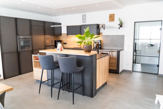 Iselküche mit Fronten aus Eisen und aus eiche umbria, auf der Bar steht eine große Pflanze