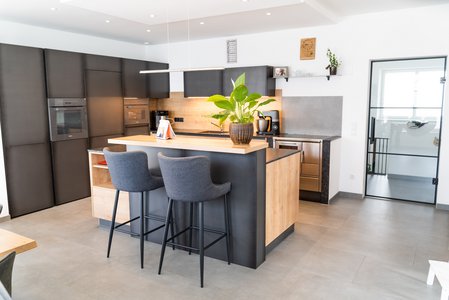 Iselküche mit Fronten aus Eisen und aus eiche umbria, auf der Bar steht eine große Pflanze