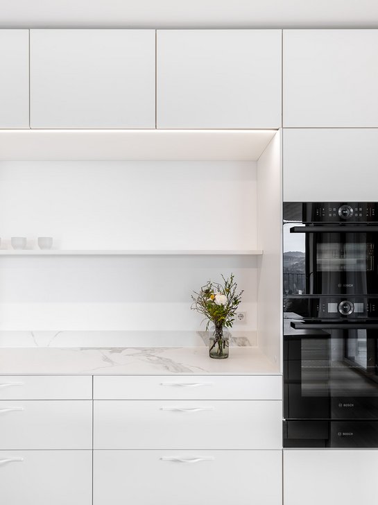 Beleuchtete Nische in weißer Küche