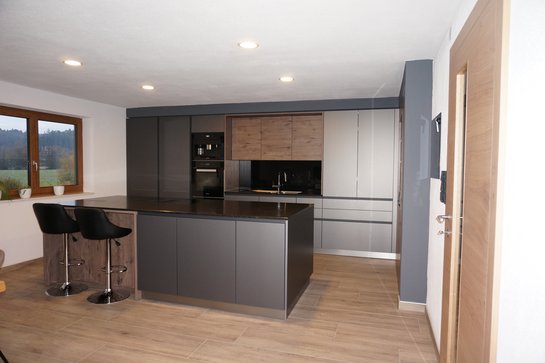 Blick in eine ewe nanoo® Küche in carbon metallic mit kombinierten Holzelementen