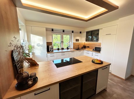 Weiße U-Küche im Landhausstil mit Rahmenfronten und Arbeitsplatte in Holzoptik