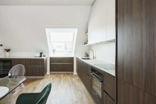 Die Kombination aus Holzoptik, hellem panna und feiner Keramik wirkt leicht und modern – perfekt angepasst an die Dachneigung.