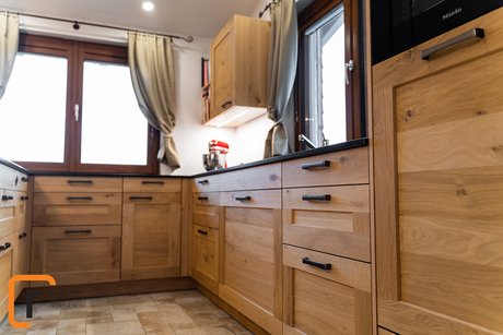 Detailansicht von Rahmenfronten einer Landhausküche aus Eiche mit schwarzen Griffen