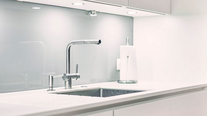 Weiße Küchenzeile mit Spülbereich mit einer Edelstahlarmatur und Edelstahlspüle