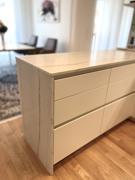 Grifflose Küchenfronten in angora mit farblich abgestimmten Griffmulden für eine ruhige, moderne Gestaltung.