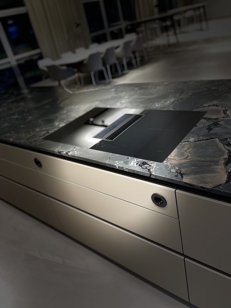 In die Kücheninsel wurde ein flächenbündig eingebautes Kochfeld integriert.