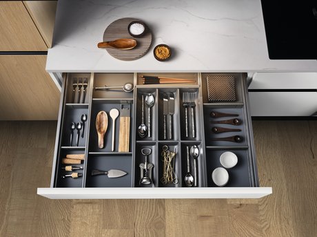 Schublade mit organisiertem Besteckeinsatz und Küchenutensilien.