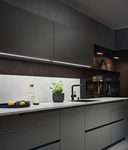 Küchenzeile in dunklem Grau mit heller Arbeitsplatte und grauen Oberschränken