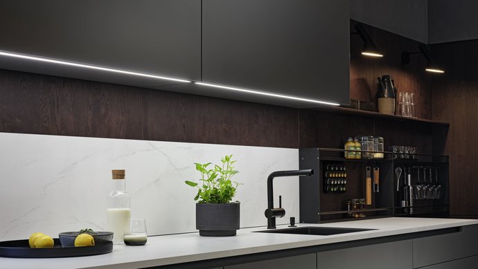 Küchenzeile in dunklem Grau mit heller Arbeitsplatte und grauen Oberschränken